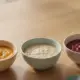 Drei Schaelchen mit Gemuese-, Getreide- und Obstbrei als Beikostplan