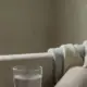 Wasserglas und Waermflasche auf dem Sofa, Blasenentzuendung Schwangerschaft