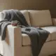 Sofaecke mit Decke, Teetasse und Handy, Corona Schwangerschaft
