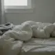 Ungemachtes Bett mit Wasserglas auf dem Nachttisch, Eltern krank