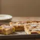 Apfelblechkuchen in Stücke geschnitten auf dem Küchentisch, Kuchen für Kindergeburtstag