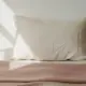 Kissen zwischen Decken auf dem Bett, Rueckenschmerzen Schwangerschaft