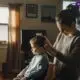 superfo_a_toddler_gets_his_hair_cut_by_his_mother_in_the_liv