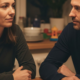 Mental Load bei beiden Elternteilen in Vollzeit: Mutter und Vater sitzen abends am Kuechentisch